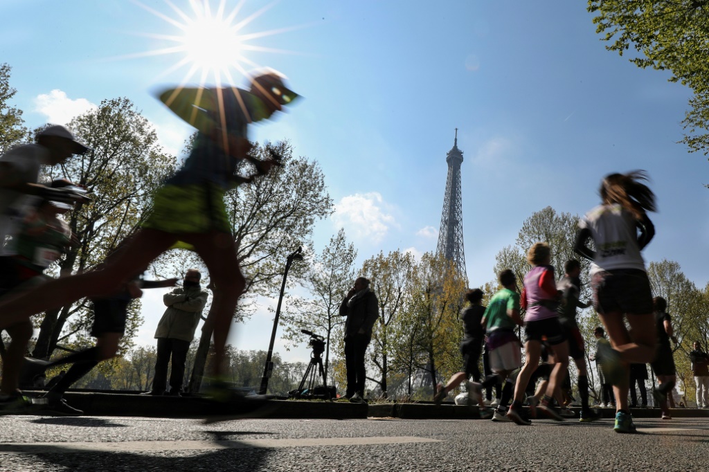 Des participants au marathon de Paris passent devant la Tour Eiffel