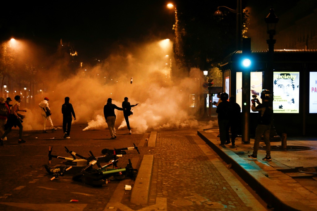 Des supporteurs du PSG shootent dans des gaz lacrymogènes sur les Champs-Elysées