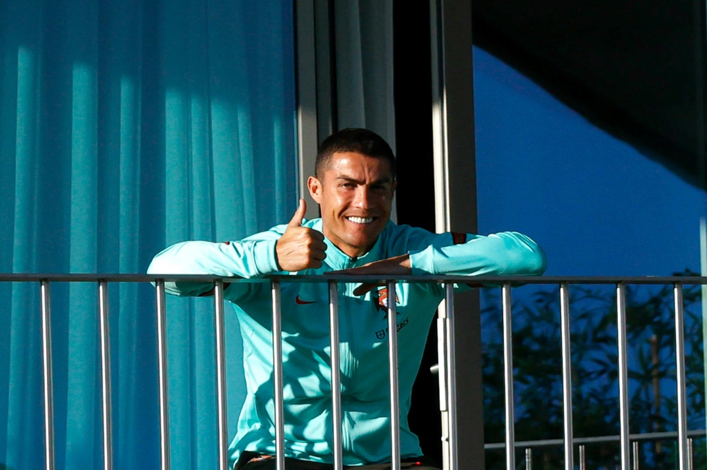 L'attaquant portugais Cristiano Ronaldo regarde ses coquipiers s'entraîner depuis un balcon au camp d’entraînement du Portugal