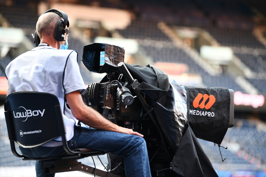 Un caméraman de télévision devant un logo du diffuseur sino-espagnol Madiapro