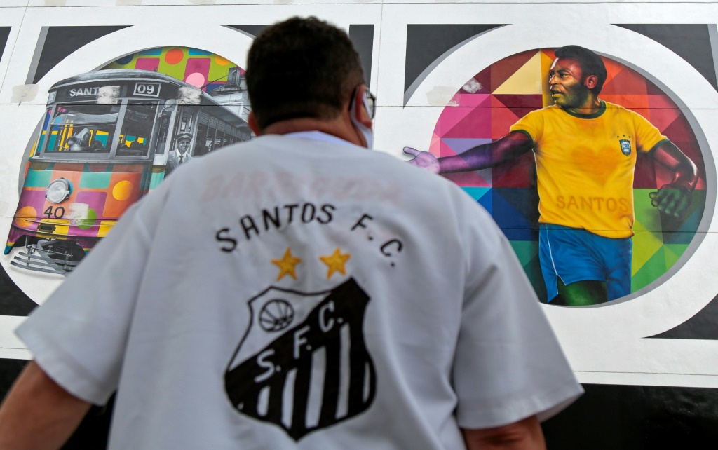 Un supporteur du club brésilien de football de Santos regarde une fresque dessinée par l'artiste brésilien Kobra représentant Pelé