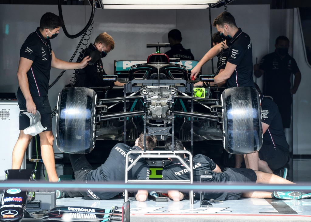 Des mécaniciens de Mercedes s'affairent autour de la monoplace du Britannique Lewis Hamilton
