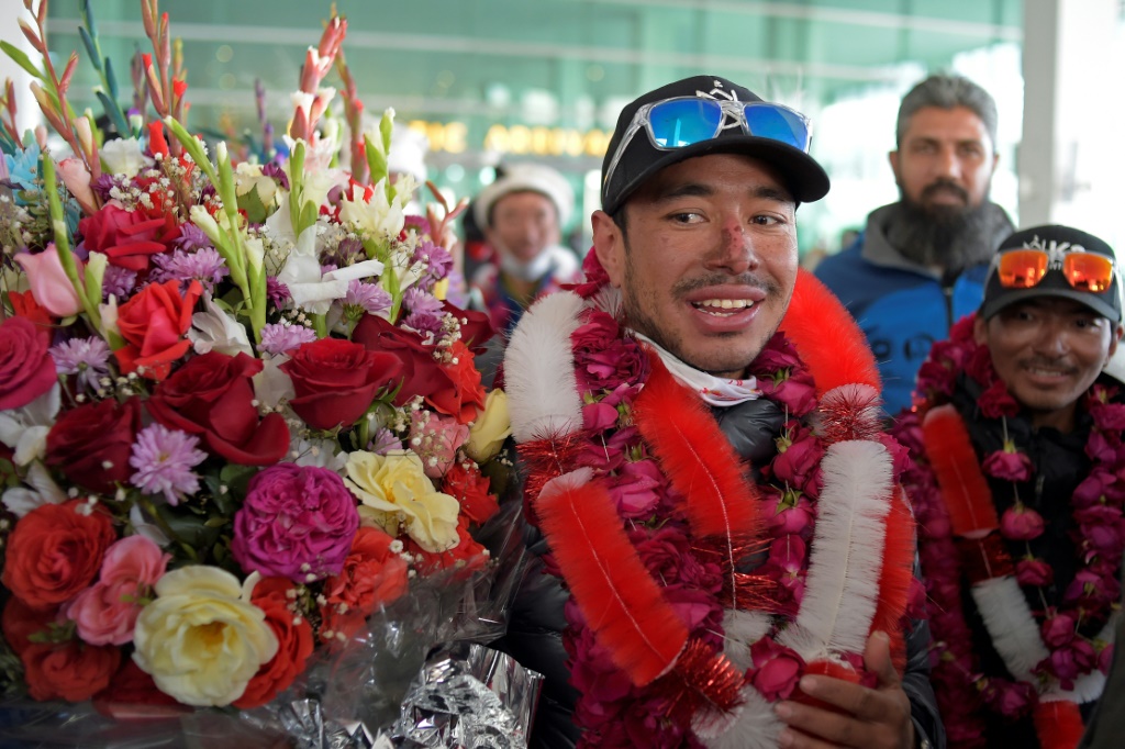 L’alpiniste népalais Nirmal Purja (c) est chaleureusement accueilli à l’aéroport d’Islamabad