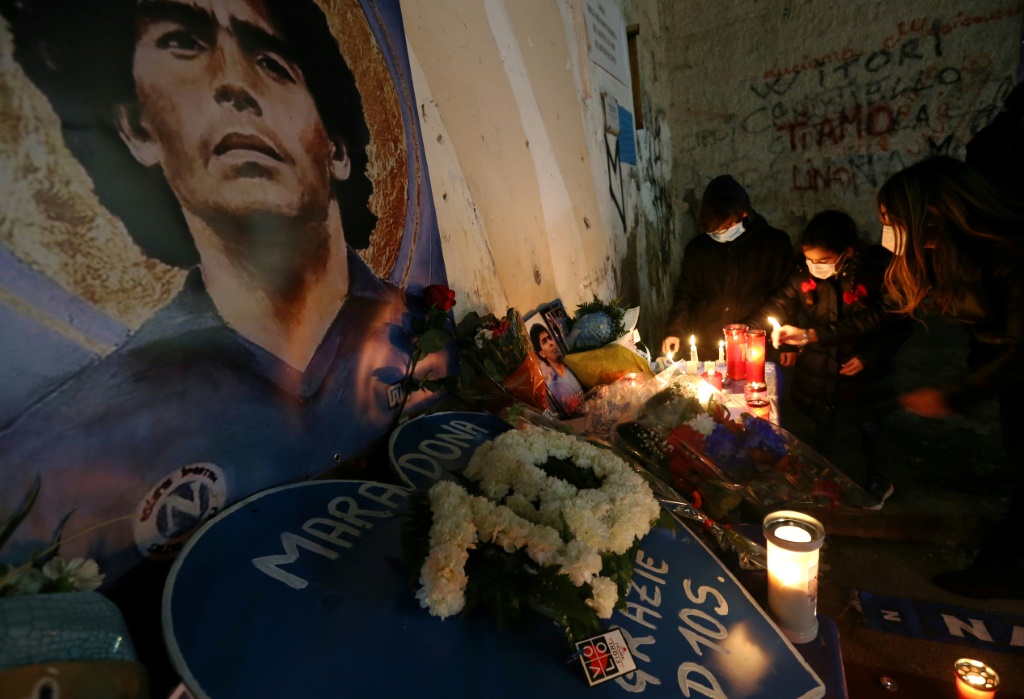 Un mémorial improvisé devant une fresque de Diego Maradona dans une rue de Naples le 26 novembre 2020