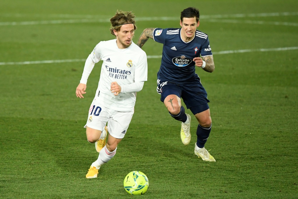 Le milieu du Real Madrid Luka Modric (g) devant l'attaquant du Celta Vigo Santi Mina