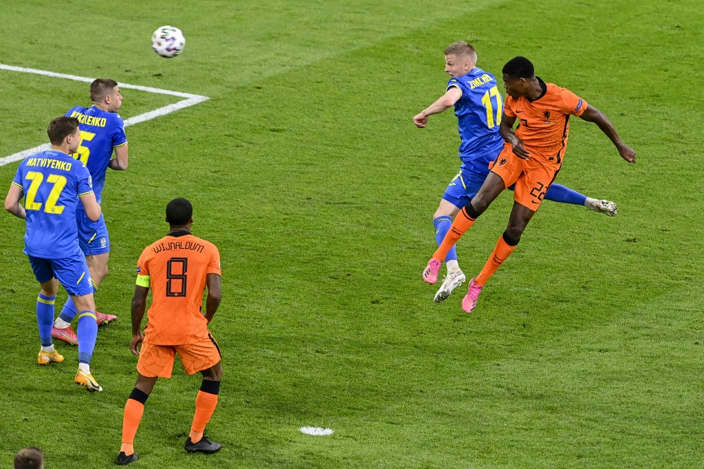 Le défenseur néerlandais Denzel Dumfries (d) marque de la tête lors du match de groupes de l'Euro