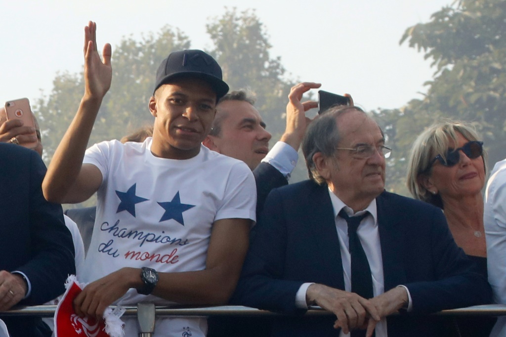 Kylian Mbappé et le président Noël Le Graët à bord d'un bus à impériale le 16 juillet 2018 à Paris, pour célébrer leur sacre mondial en Russie