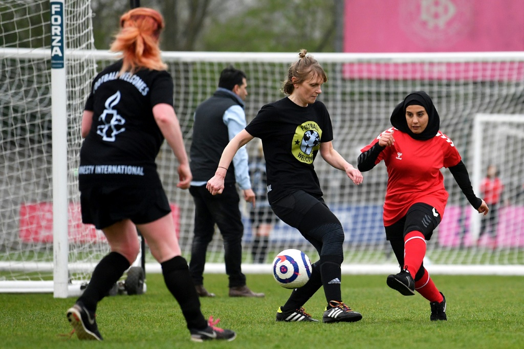 Une joueuse afghane de l'équipe nationale espoirs face à des députées britanniques, lors d'une rencontre organisée par Amnesty International, le 29 mars 2022 dans le stade de Dulwich Hamlet FC au sud de Londres