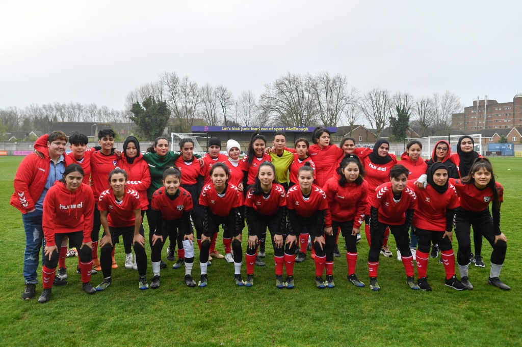 L'équipe nationale afghane espoirs pose avant son match contre des députées britanniques, lors d'une rencontre organisée par Amnesty International, le 29 mars 2022 dans le stade de Dulwich Hamlet FC au sud de Londres