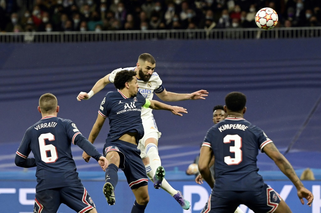 L'attaquant français du Real Madrid, Karim Benzema, saute plus haut que le défenseur brésilien du Paris Saint-Germain, Marquinhos, lors du 8e de finale retour de la Ligue des Champions, le 9 mars 2022 au Stade Santiago Bernabeu