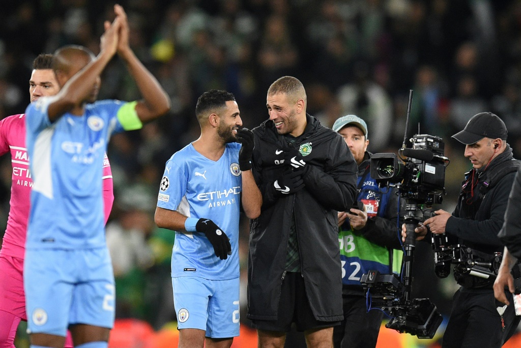 Le milieu de terrain algérien de Manchester City, Riyad Mahrez (g) discute avec son compatriote du Sporting Lisbonne, l'attaquant Islam Slimani, après leur match nul (0-0 en 8e de finale retour de la Ligue des Champions, le 9 mars 2022 à l'Etihad Stadium