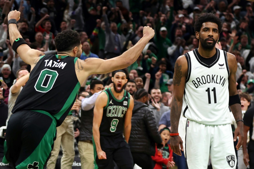 Jayson Tatum (Boston Celtics) lève les bras au ciel, sous les yeux de Kyrie  Irving (Brooklyn Nets) après avoir marqué le panier victorieux de son équipe (115-114) à la dernière seconde du premier match de play-offs remporté samedi à Boston