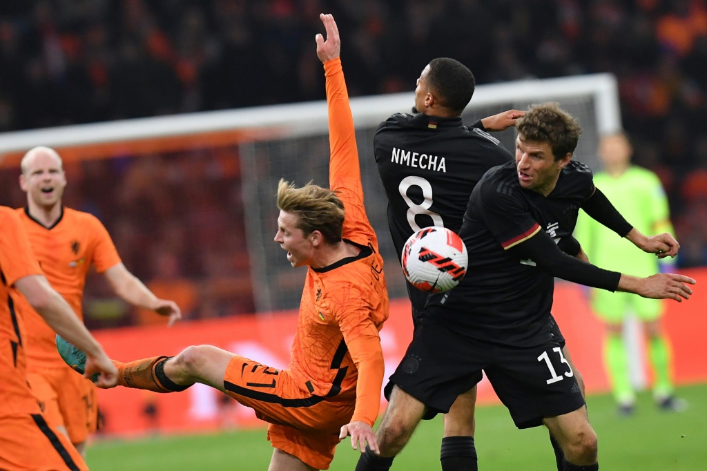L'attaquant allemand Thomas Müller (#13) gagne son duel avec le milieu des Pays-Bas Frenkie De Jong en match amical à Amsterdam, le 29 mars 2022