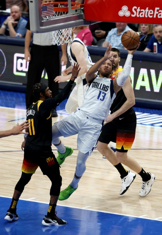Jalen Brunson des Dallas Mavericks shoote de façon acrobatique contre le Utah Jazz en play-off NBA le 18 avril 2022 à l'American Airlines Center à Dallas