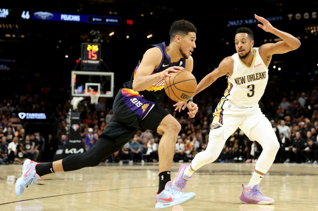 Devin Booker des Phoenix Suns face à CJ McCollum des New Orleans Pelicans en match des plays-offs NBA le 19 avril 2022 à Phoenix