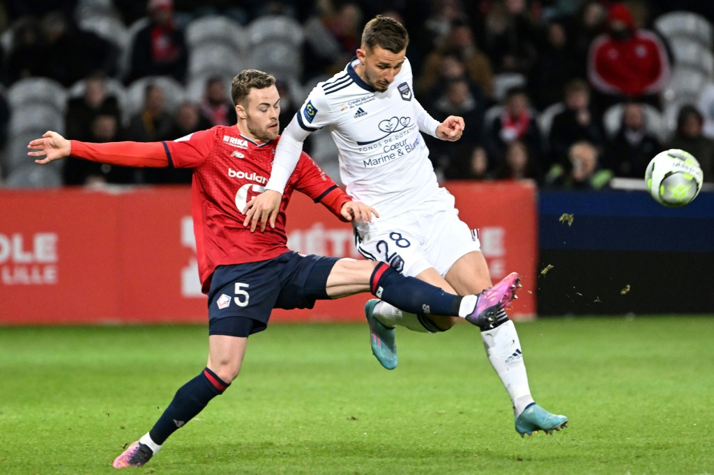 L'attaquant de Bordeaux Rémi Oudin (d) à la lutte avec le défenseur lillois Gabriel Gudmundsson, le 2 avril 2022 à Lille