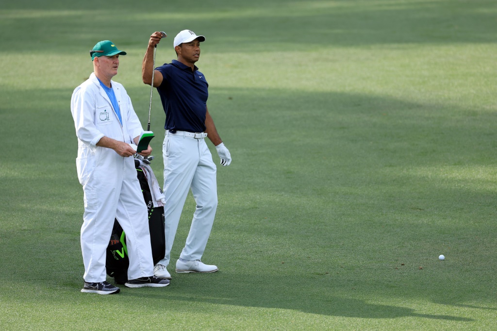 Tiger Woods échange avec son caddie Joe LaCava à l'entraînement pour le Masters d'Augusta, le 5 avril 2022