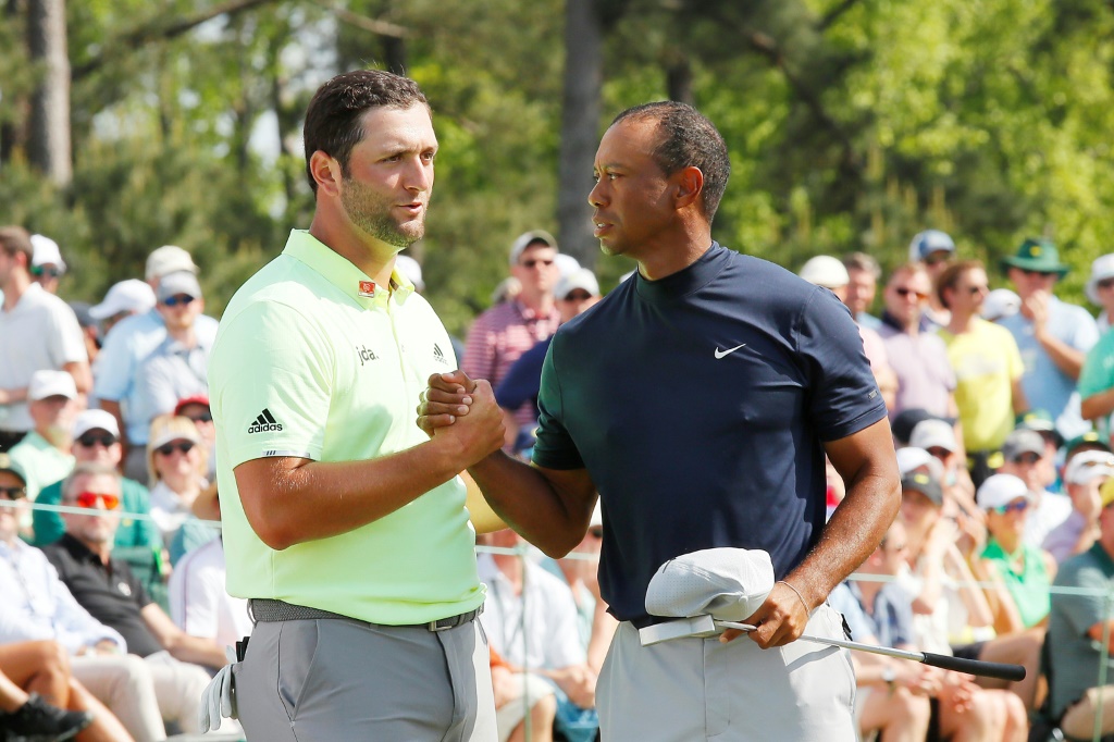 L'Espagnol Jon Rahm et l'Américain Tiger Woods se congratulent sur le 18e trou, après avoir terminé le 1er tour du Masters d'Augusta (Géorgie), le 11 avril 2019