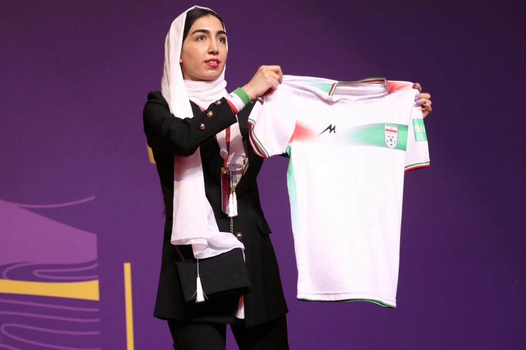 Une supportrice iranienne pose avec le maillot de son équipe nationale avant le tirage au sort du Mondial à Doha, le 1er avril 2022