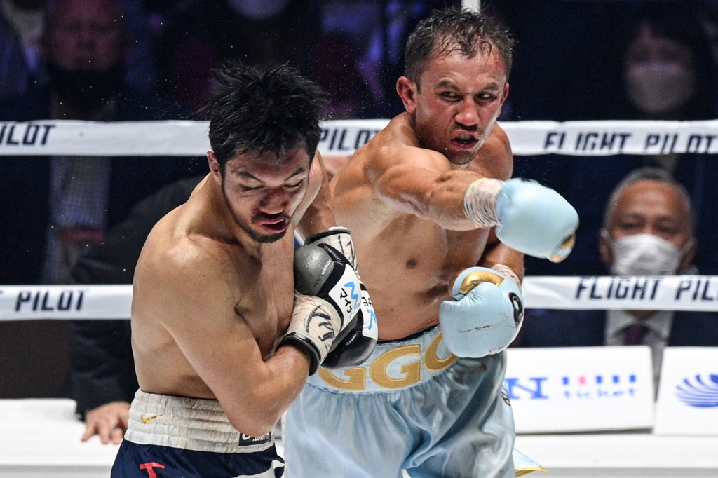 Le Kazakh Gennady Golovkin touche d'un crochet du droit le Japonais Ryota Murata, lors de leur combat des poids moyens pour les ceintures IBF, IBO et WBA, le 9 avril 2022 à Saitama, au nord de Tokyo