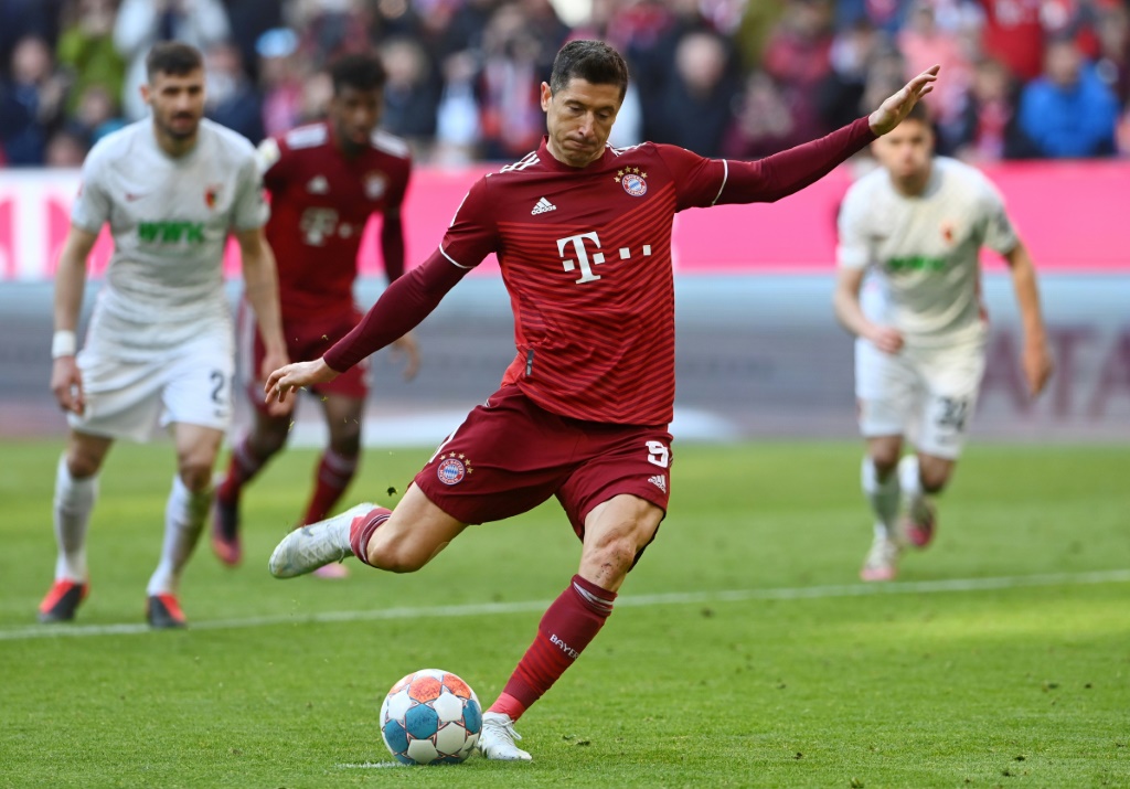 L'attaquant polonais Robert Lewandowski marque sur penalty le but de la victoire du Bayern Munich, 1-0 face à Augsbourg, lors de la 29e journée de Bundesliga, le 9 avril 2022 à l'Allianz Arena