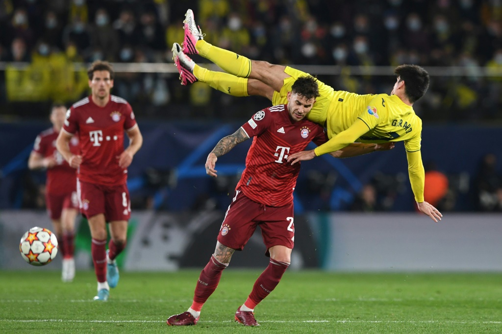 L'attaquant de Villareal Gerard Moreno est bousculé à domicile par le défenseur français du Bayern Munich Lucas Hernandez, lors du quart de finale aller de la Ligue des Champions, le 6 avril 2022 à