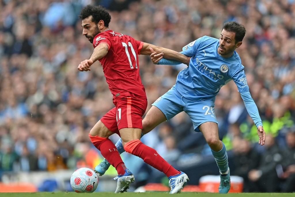 L'attaquant égyptien de Liverpool Mohamed Salah tente de dribbler le milieu de terrain portugais de Manchester City Bernardo Silva, lors de leur match de la 32e journée de Premier League, le 10 avril 2022 à l'Etihad Stadium