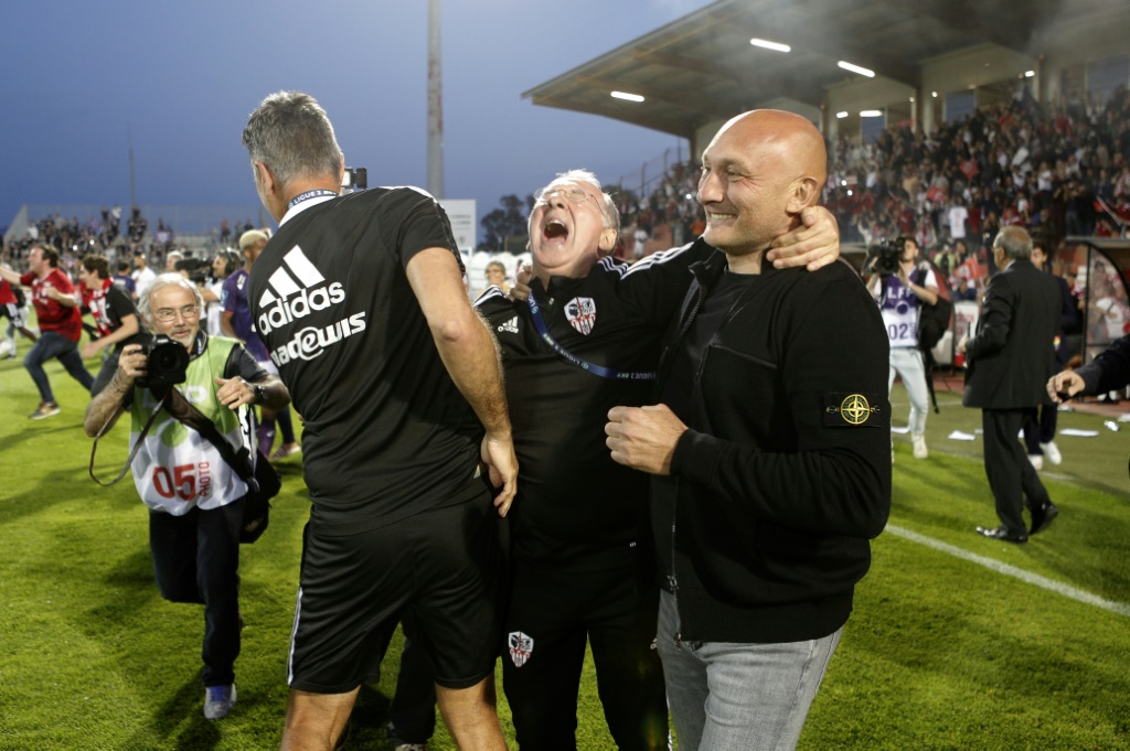 Le coach de l'AC Ajaccio Olivier Pantaloni (à droite) fête la montée de son équipe en Ligue 1 avec son staff après la victoire sur Toulouse en Corse