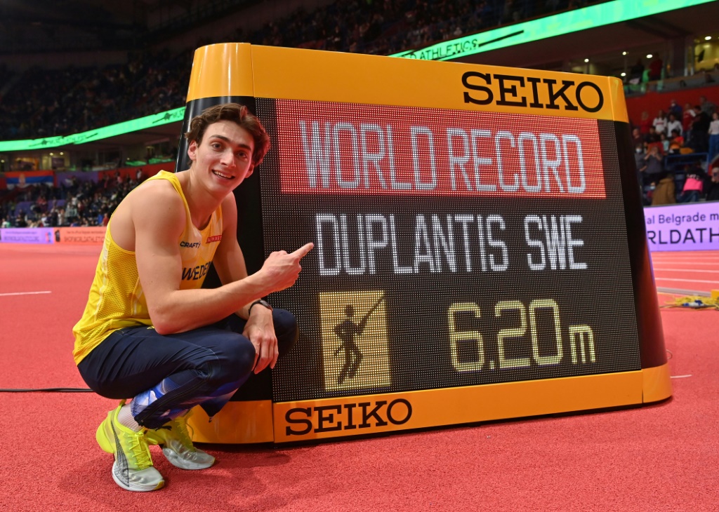 Le perchiste suédois Armand Duplantis pose devant la marque de son nouveau record du monde (6,20 m), aux Mondiaux en salle à Belgrade, le 20 mars 2022