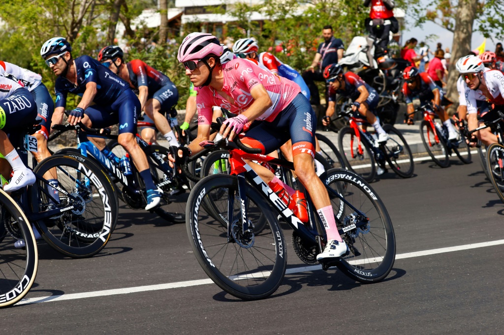 Juan Pedro Lopez roulant avec le peloton, a conservé  le maillot rose de leader du Giro à à Naples, le 14 mai 2022