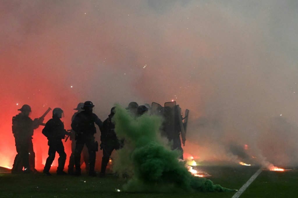 Heurts entre des policiers et des supporters de Saint-Etienne qui ont envahi le terrain après la défaite du club contre Auxerre, à Saint-Etienne le 29 mai 2022