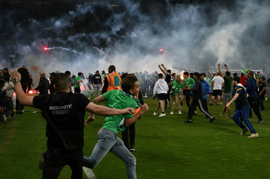 Des supporters de Saint-Etienne envahissent le terrain du stade Geoffroy-Guichard après la défaite de leur club contre Auxerre, le 29 mai 2022