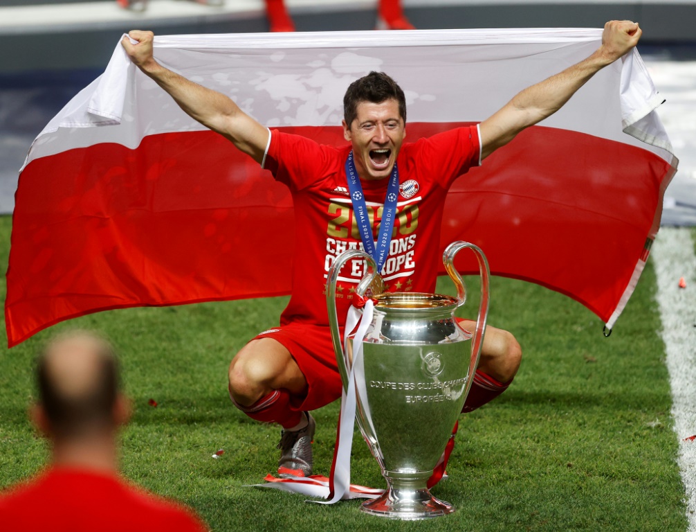 L'attaquant polonais Robert Lewandowski pose avec un drapeau de son pays, après la victoire du Bayern Munich, 1-0 face au Paris Saint-Germain, en finale de la Ligue des Champions, le 23 août 2020 à Lisbonne
