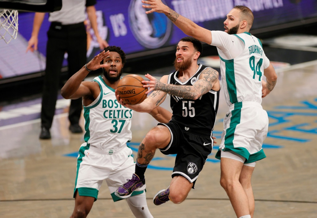 L'arrière des Brooklyn Nets Mike James s'infiltre entre l'ailier Semi Ojeleye et l'arrière français Evan Fournier des Boston Celtics, lors de leur match de NBA, le 23 avril 2021 à Brooklyn