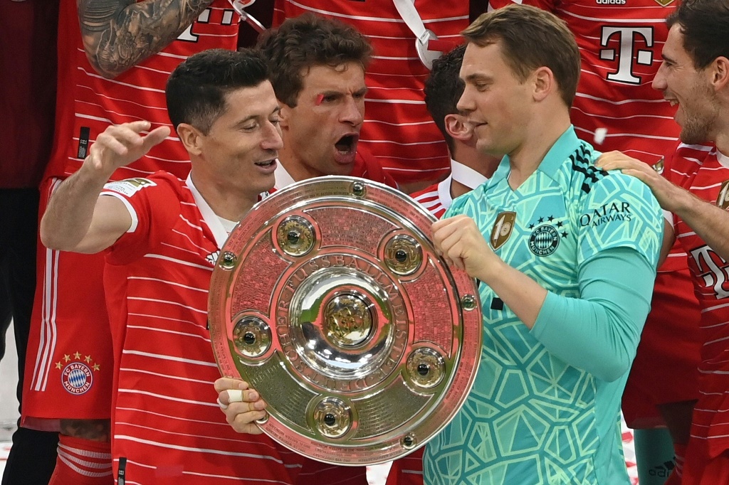 Les joueurs du Bayern Robert Lewandowski (g), Thomas Müller (c) et Manuel Neuer avec le trophée de champion d'Allemagne présenté au public après le match contre Stuttgart, le 8 mai 2022 à Munich
