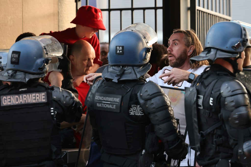 Des policiers font face à des supporters madrilènes avant le coup d'envoi de la finale de la Ligue des champions devant le Stade de France situé à Saint-Denis près de Paris