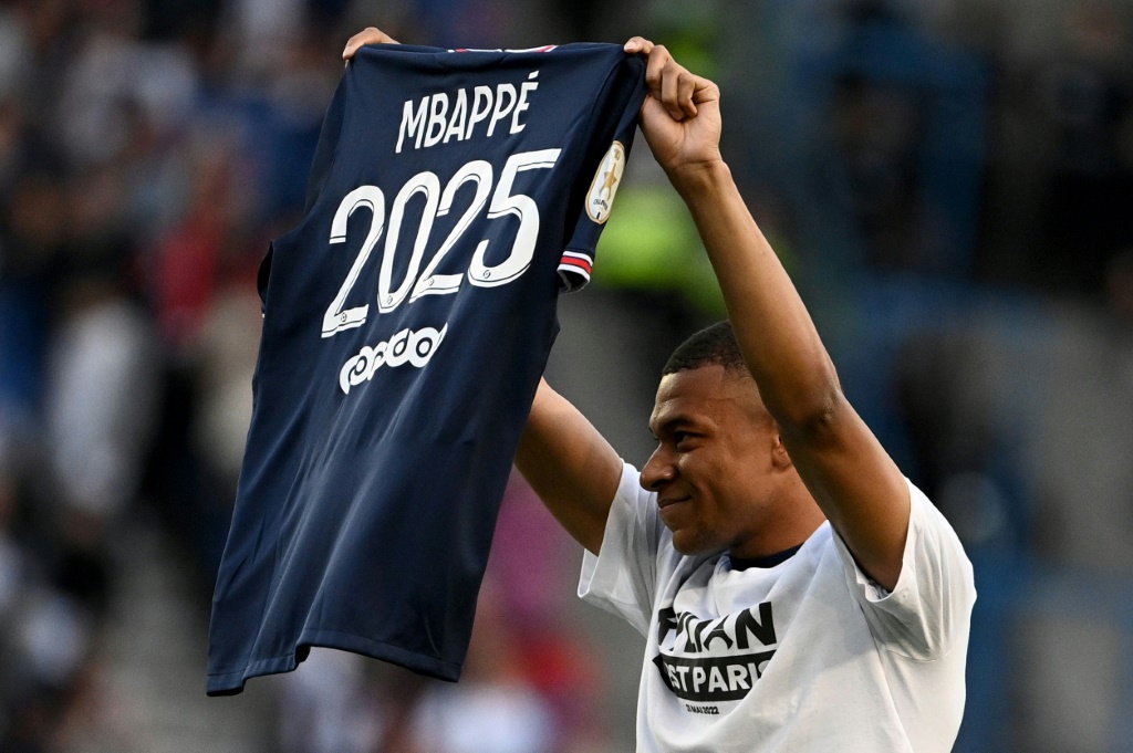 L'attaquant du PSG Kylian Mbappé pose avec son maillot officialisant sa prolongation jusqu'en 2025 avant la rencontre de Ligue 1 entre Paris et Metz le 21 mai 2022 au Parc des Princes