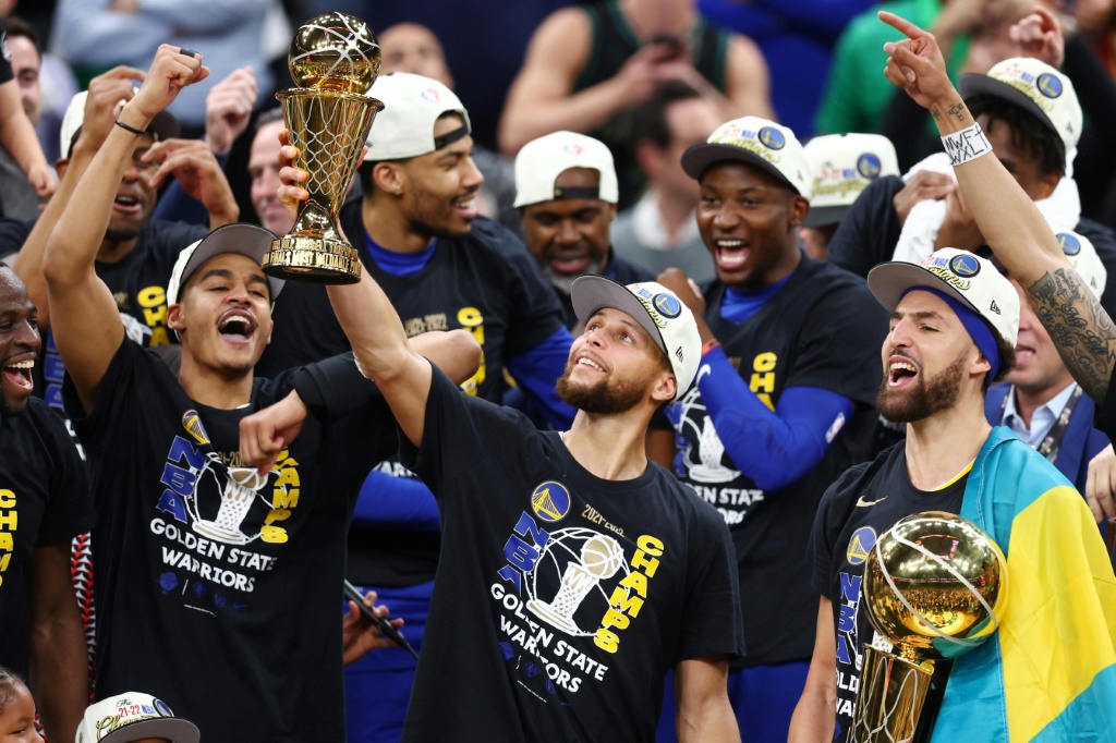 Stephen Curry (au centre), avec en main son premier trophée de meilleur joueur de la finale NBA, le 16 juin 2022 à Boston.