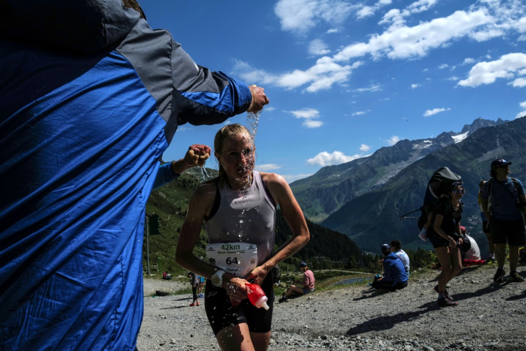 Une athlète se raffraîchit sur sa route lors du marathon du Mont Blanc à Chamonix, le 26 juin 2022