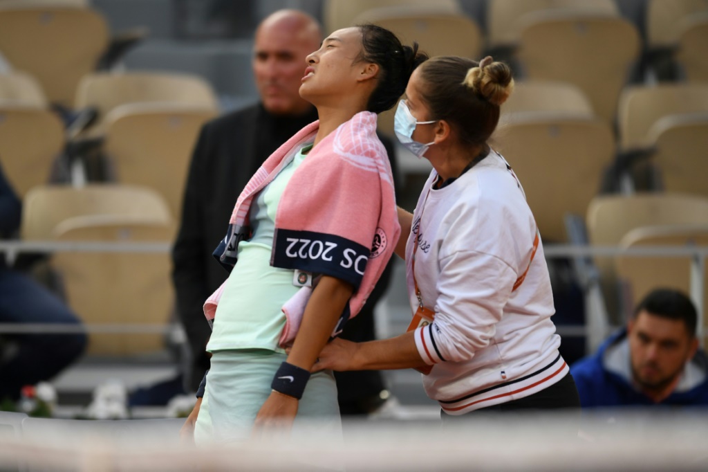 La Chinoise Qinwen Zheng se fait masser le dos lors d'un temps mort médical, au cours de son 8e de finale contre la Polonaise Iga Swiatek, le 30 mai 2022 au tournoi de Roland-Garros