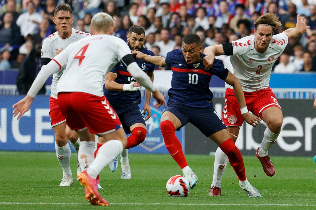 L'attaquant star des Bleus Kylian Mbappé (C) tente de percer le rideau défensif danois au Stade de France, le 3 juin 2022
