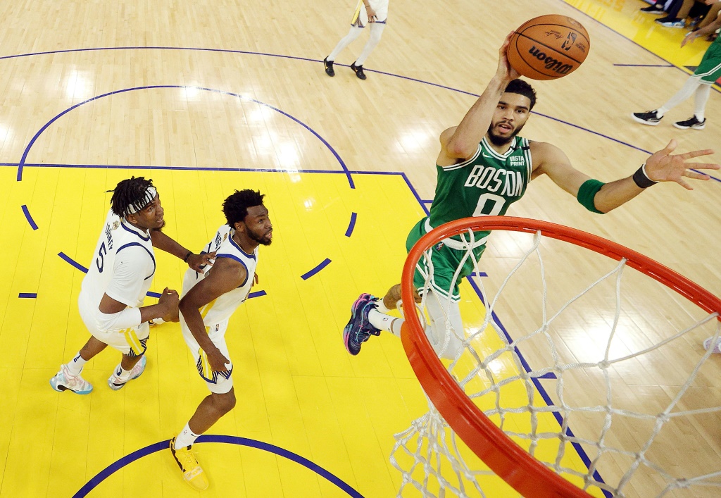 Jayson Tatum (Boston Celtics) shoote sous les yeux d'Andrew Wiggins #22 et Kevon Looney #5, les joueurs des Golden State Warriors, pendant le Match 1 de la Finale NBA au Chase Center de San Francisco le 2 juin 2022