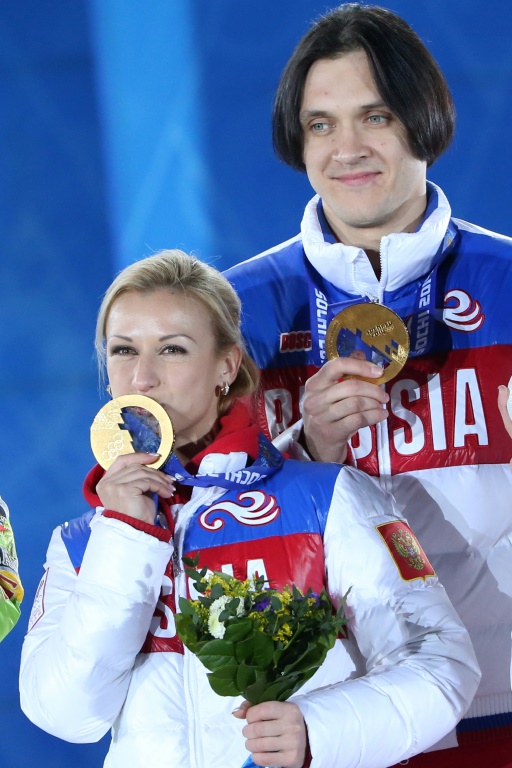 Les Russes Tatiana Volosozhar et Maxim Trankov sur le podium des Jeux olympiques de Sotchi le 13 février 2014 avec leur médaille d'or remportée en couple