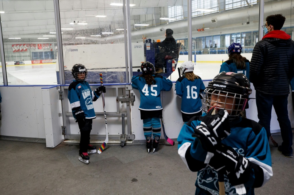 Séquence de détente pour des jeunes Canadiennes dans leur vestiaire avant un entraînement de hockey à Toronto, le 24 mars 2022