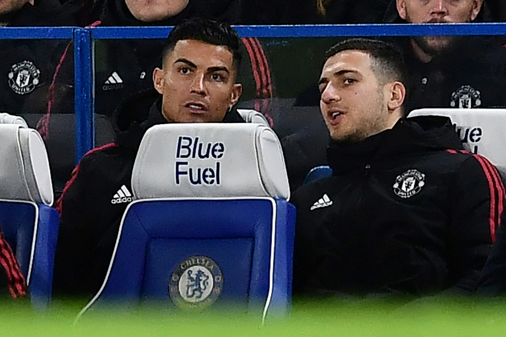 Les Portugais Cristiano Ronaldo et Diogo Dalot discutent sur le banc de touche de Manchester United, lors d'un match face à Chelsea, le 28 novembre 2021 à Stamford Bridge