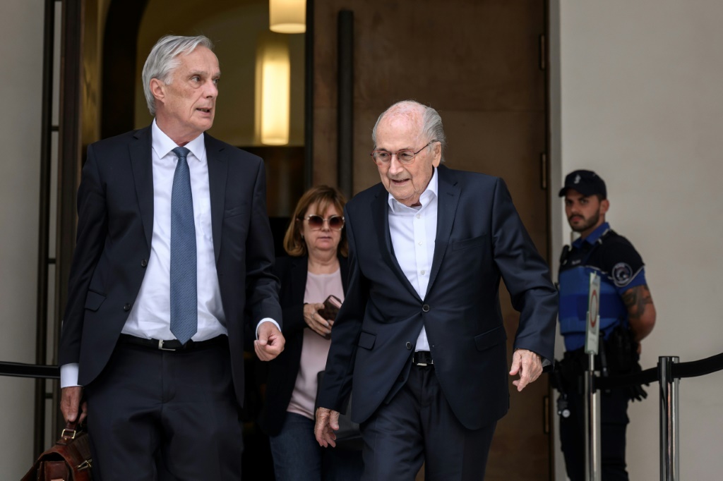 L'ex-président de la Fifa Sepp Blatter (au centre), quitte le tribunal pénal de Bellinzone en compagnie de son avocat Lorenz Erni et de sa fille Corinne Blatter, le 8 juin 2022