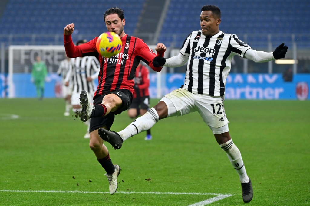 Le défenseur de l'AC Milan Davide Calabria dégage le ballon devant son homologue brésilien de la Juventus Turin, Alex Sandro, lors du match de la 23e journée de Serie A, le 23 janvier 2022 au Stade San Siro