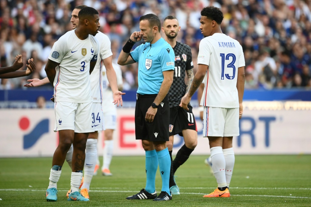 Le capitaine des Bleus Presnel Kimpembé échange avec l'arbitre israélien Orel Grinfeld à propos d'un penalty siflé pour la Croatie au Stade de France, le 13 juin 2022