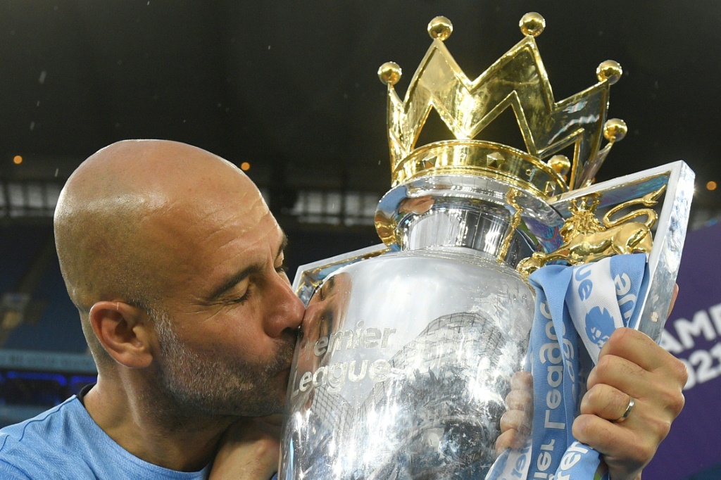 L'entraîneur espagnol de Manchester City Pep Guardiola embrasse le trophée de la Premier League, après avoir remporté le titre, lors de la 38e et dernière journée en battant à domicile Aston Villa (3-2), le 22 mai 2022 à l'Etihad Stadium
