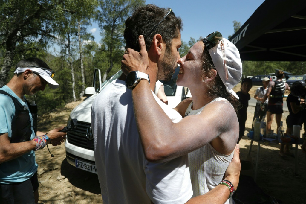 La traileuse Anne-Lise Rousset embrasse son mari et coach de l'équipe de France, Adrien Séguret, le 13 juin 2022 au col de Vergio, lors d'une pause dans un point relais pendant sa tentative de battre le record féminin du mythique GR20 en Corse